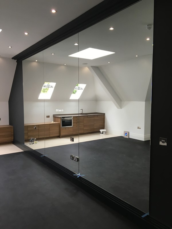 Frameless glass partition in loft conversion by Poplar glaziers