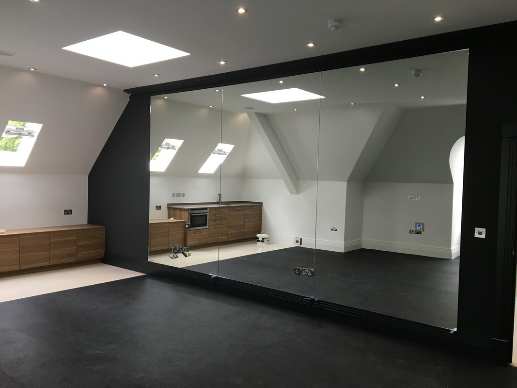 Frameless glass wall dividing loft conversion in Poplar